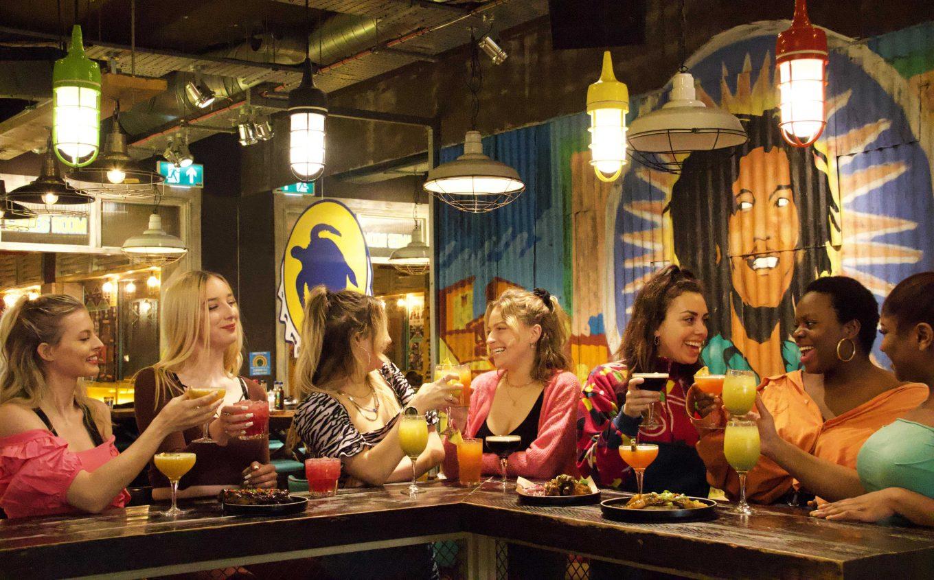 Group of girls enjoying delicious 2-4-1 tropical cocktails